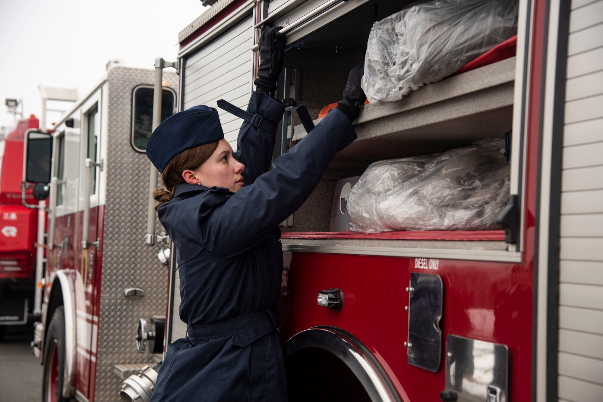 U.S. Air Force Airman 1st Class Yuki Lubbers, a 35th Civil Engineer Squadron firefighter closes a hatch on a fire truck during the annual Misawa City Fire Department New Year ceremony at Misawa City, Japan, Jan. 20, 2019. Along with the Misawa City fire department units, the 35th CES showcased their response times to emergencies. After the demonstration, first responders paraded around the block to say hello to locals. (U.S. Air Force photo by Senior Airman Sadie Colbert)