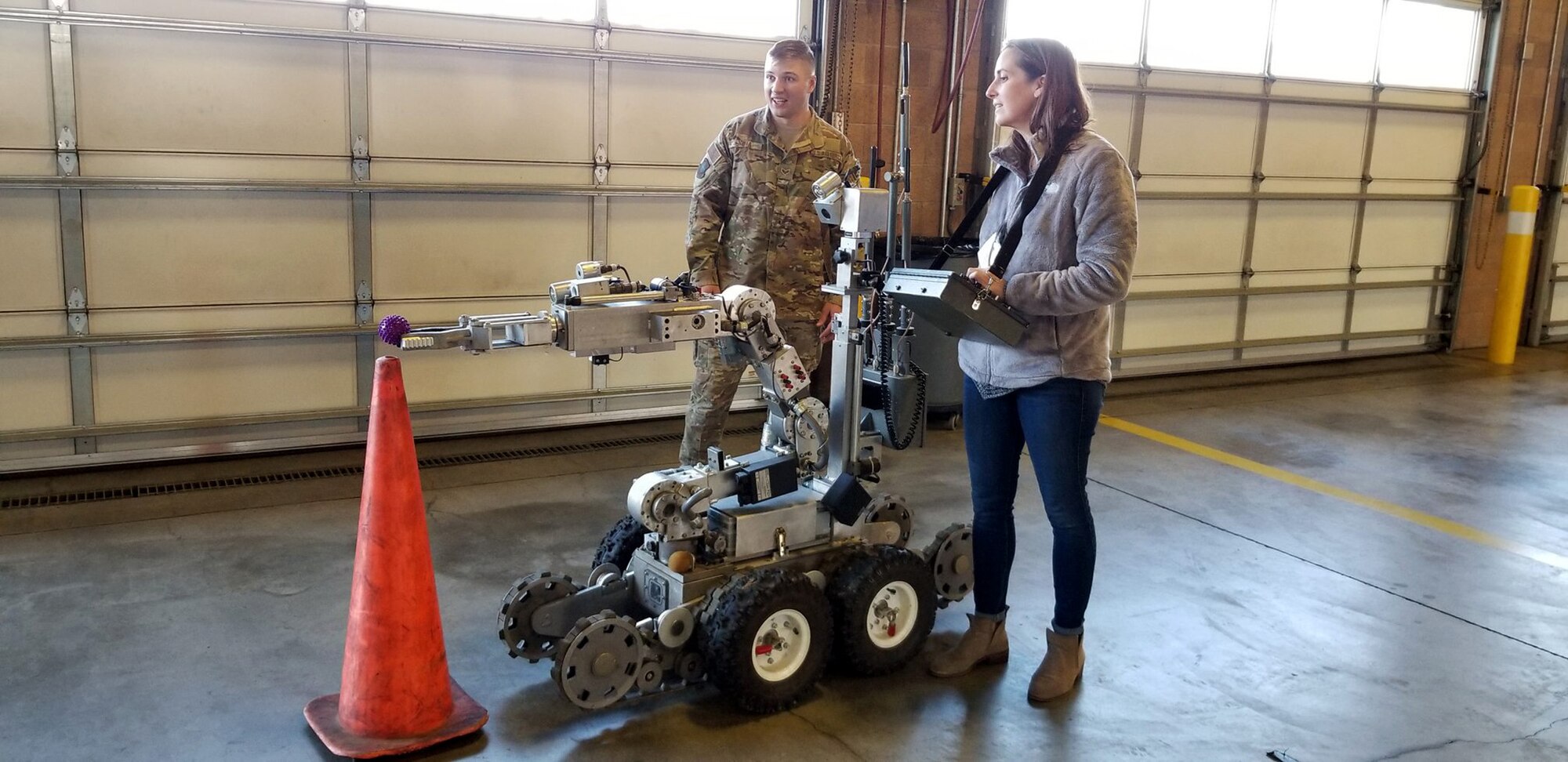 60th Explosive Ordinance Disposal Airman helps Christi Coors Ficeli maneuver a robot to retrieve an "explosive" device. She is the HC to 349th Mission Support Group commander, Col. Rod Grunwald.