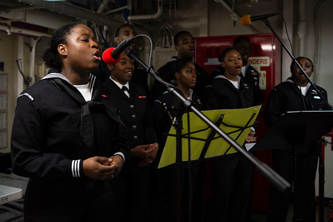 Sailors singing into microphones.