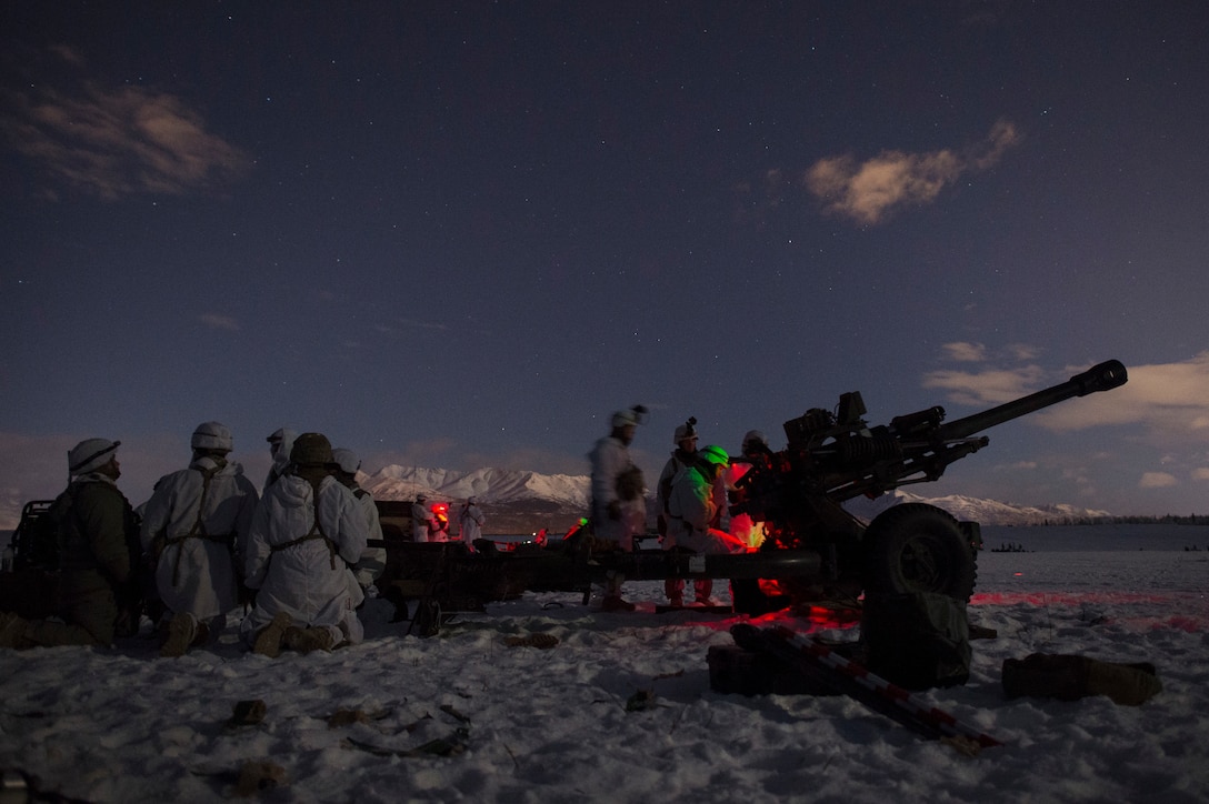 Two soldiers setting up a gun while others sit behind.