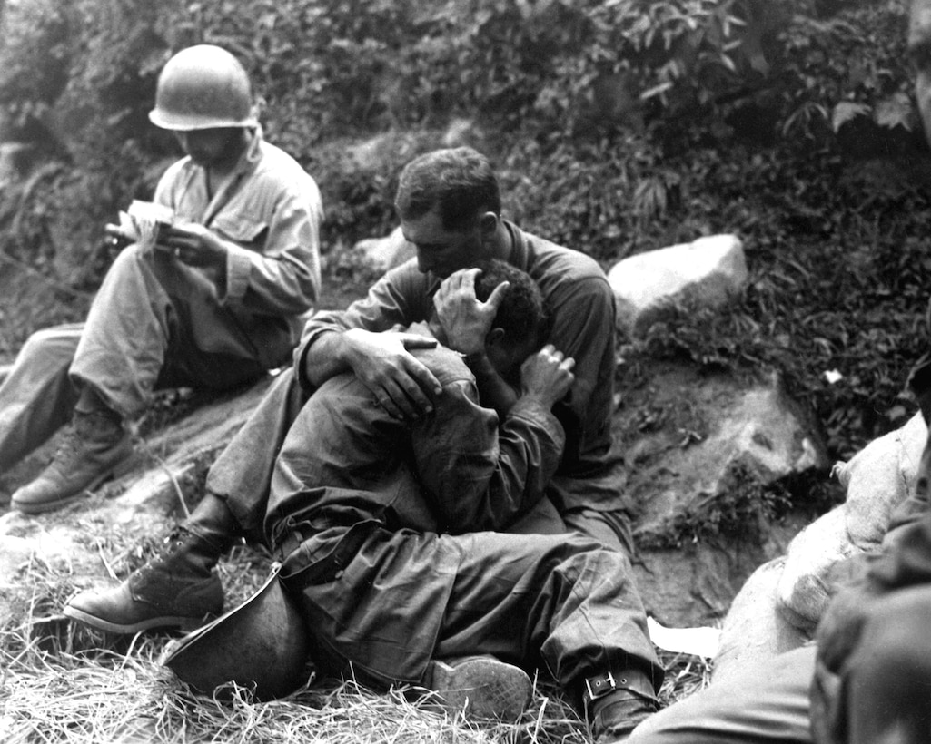 Grief-stricken American Infantryman whose buddy was killed in action is comforted by another Soldier, August 28, 1950, Haktong-ni area, Korea (U.S. Army/Al Chang)