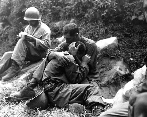 Grief-stricken American Infantryman whose buddy was killed in action is comforted by another Soldier, August 28, 1950, Haktong-ni area, Korea (U.S. Army/Al Chang)