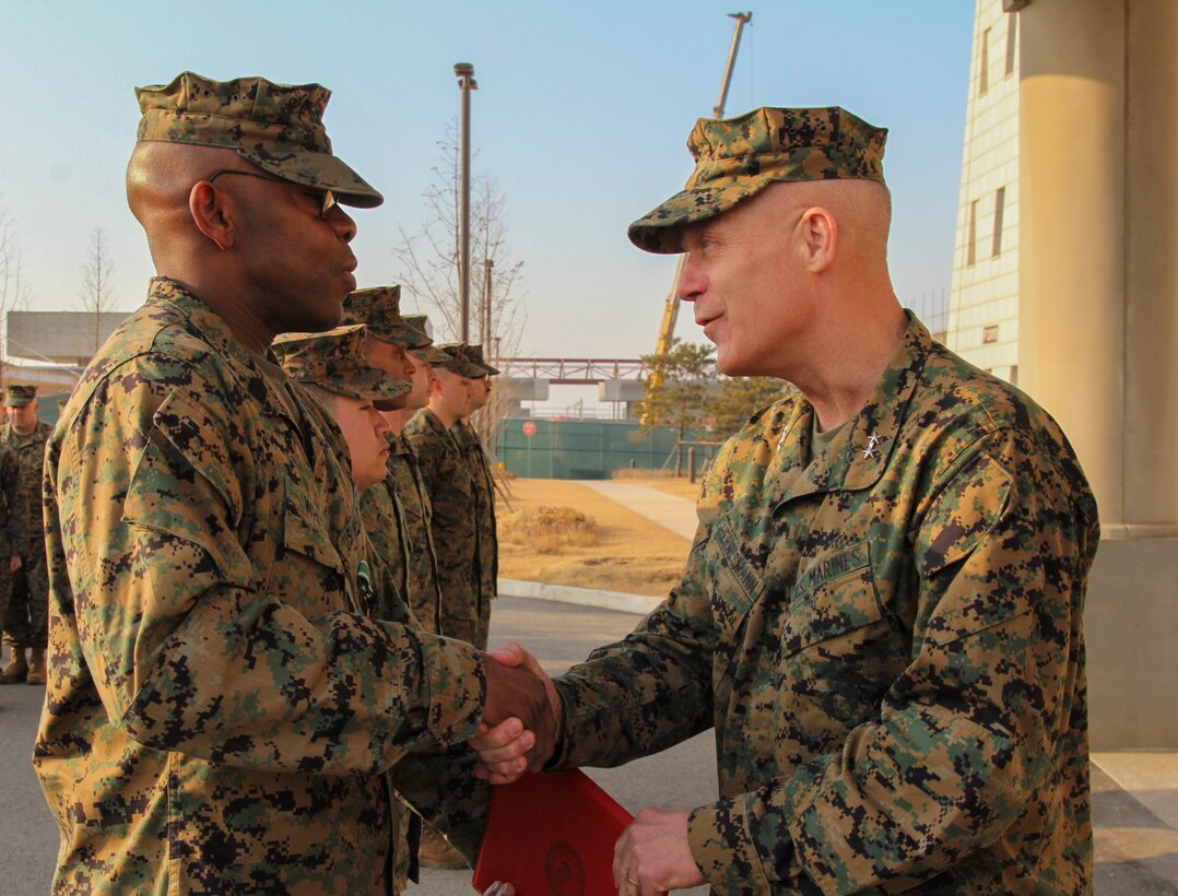 CAMP HUMPHREYS, Republic of Korea – Master Sgt. Olatokunb A. White, U.S. Marine Corps Forces Korea G-6 communications chief, receives the Navy and Marine Corps Commendation Medal from Maj. Gen. Patrick J. Hermesmann, MARFORK commander, here, Jan. 22. White led the communications section of MARFORK and helped set the force for Marine Corps communications in Korea. (Official U.S. Marine Corps photos by Sgt. Nathaniel Hanscom/Released)