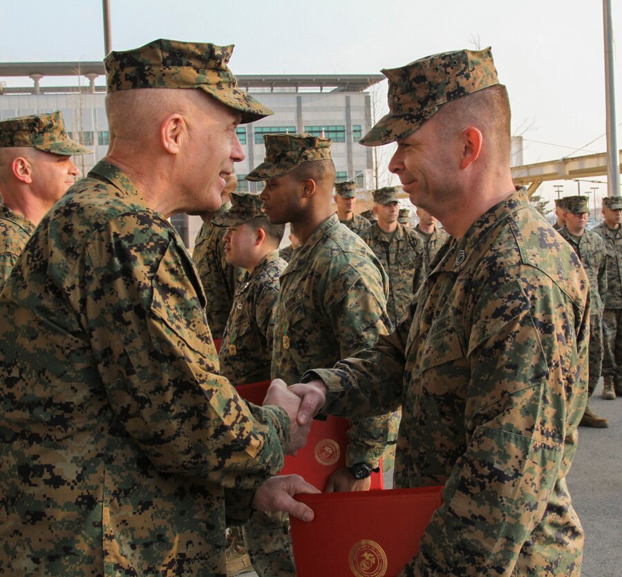 CAMP HUMPHREYS, Republic of Korea – Gunnery Sgt. Roger Reyes, U.S. Marine Corps Forces Korea ammunitions chief, receives a Certificate of Commendation from Maj. Gen. Patrick J. Hermesmann, MARFORK commander, here Jan. 22. Reyes was awarded the CERTCOM for excellence in putting together and leading the Camp Humphreys Chili Cook Off held by MARFORK in conjunction with the Army versus Navy football game. (Official U.S. Marine Corps photos by Sgt. Nathaniel Hanscom/ Released)