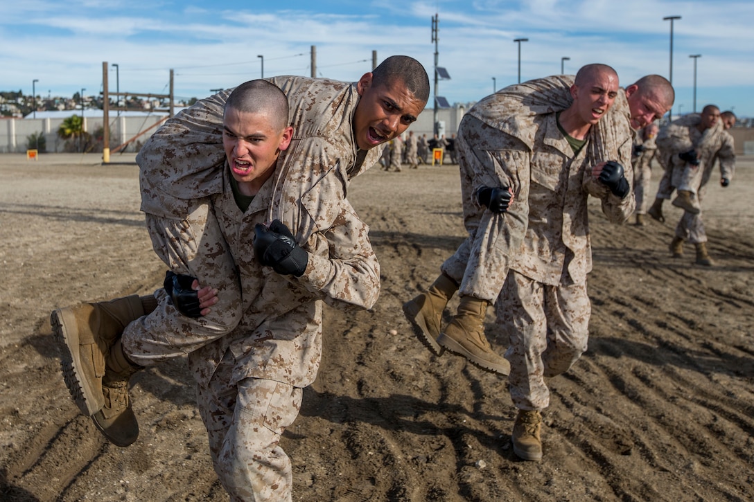Marine recruits carry each other.