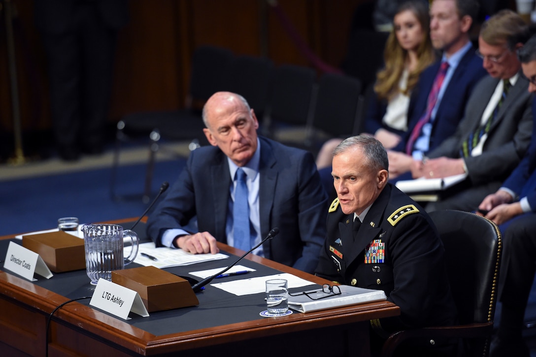 A soldier and a civilian sit at a table.