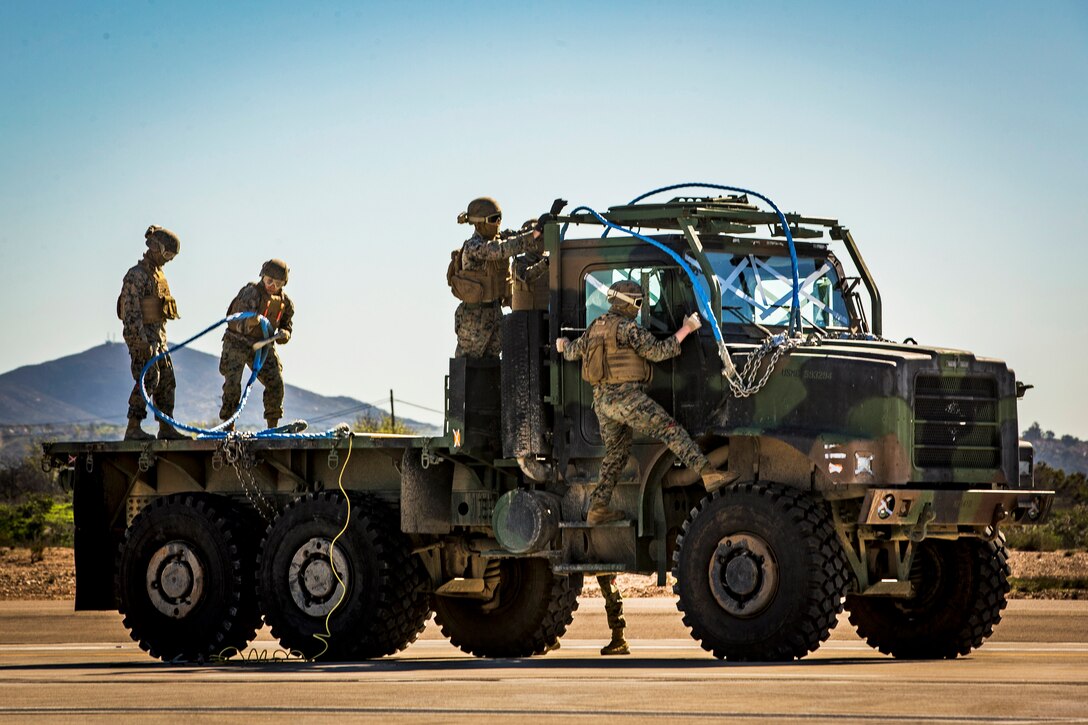 Several Marines prepare a truck for training.