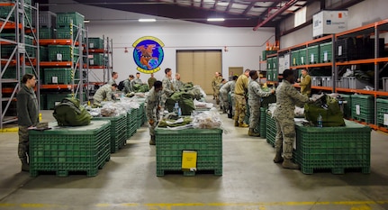 Airmen inspect their issued equipment during a pre-deployment function line exercise Jan. 23, 2019, at Joint Base Charleston, S.C.