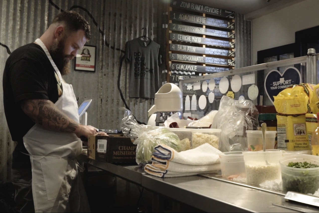 Chef gets mushrooms from a box while preparing a meal