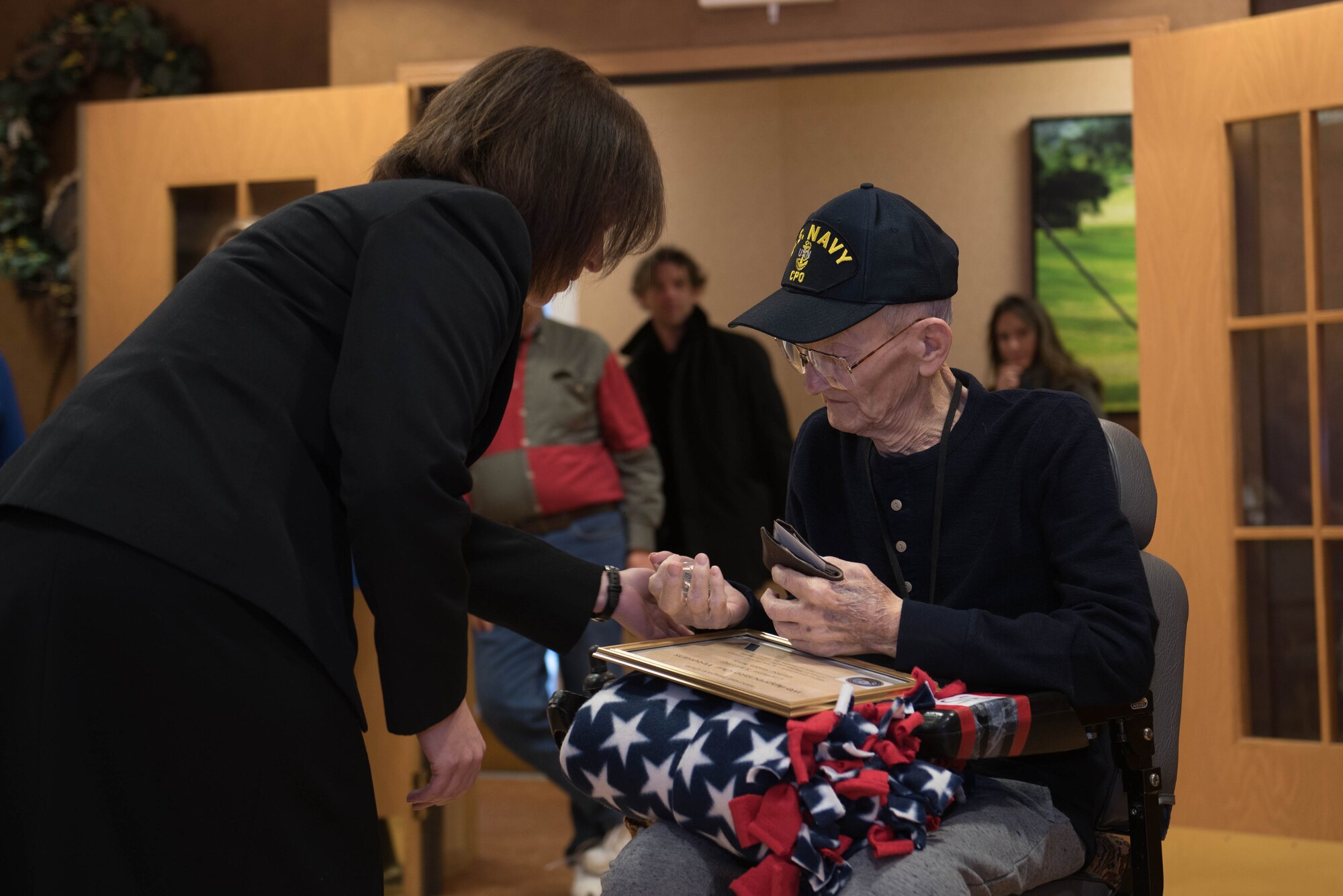 Senior Chief Petty Officer Lisa Vrtiska, U.S. Strategic Command Navy Element senior enlisted leader, presents a pin to Navy veteran Chief Petty Officer Leonard Kulceski during a veteran recognition ceremony at Hillcrest Mable Rose in Papillion, Nebraska, Jan. 18, 2019. Kulceski was named the youngest chief petty officer. (U.S. Air Force photo by Zachary Hada)