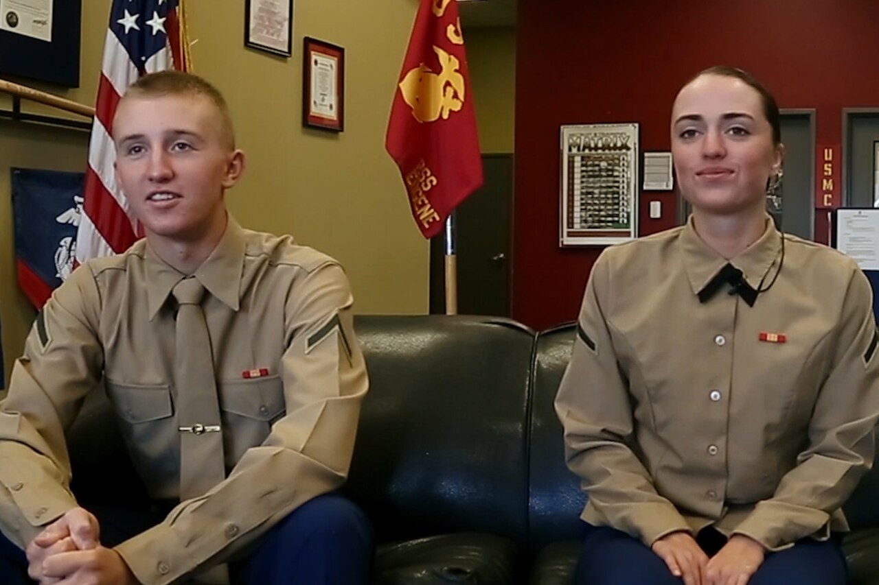 Two Marines sit on a couch.