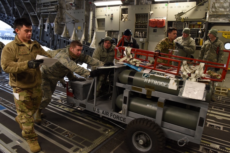 Members of the 8th Logistics Readiness Squadron assist loading nitrogen tanks onto a C-17 Globemaster III at Kunsan Air Base, Republic of Korea, Jan. 15, 2019. The 8th LRS support the loading and unloading transient aircraft that flow through the base. (U.S. Air Force photo by Staff Sgt. Joshua Edwards)