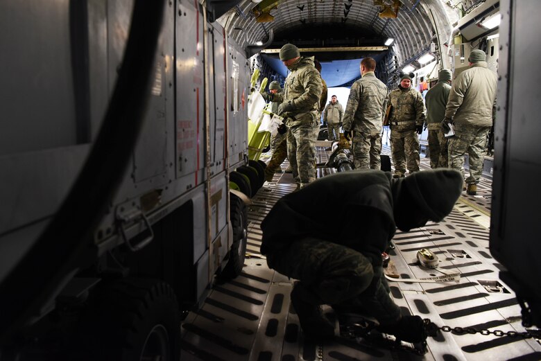 Members of the 8th Logistics Readiness Squadron secure and load cargo onto a C-17 Globemaster III at Kunsan Air Base, Republic of Korea, Jan. 15, 2019. The 8th LRS support the loading and unloading transient aircraft that flow through the base. (U.S. Air Force photo by Staff Sgt. Joshua Edwards)