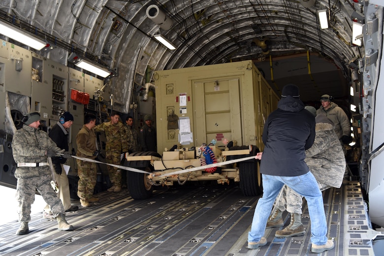 Members of the 8th Logistics Readiness Squadron steer a cargo truck onto a C-17 Globemaster III at Kunsan Air Base, Republic of Korea, Jan. 17, 2019. The 8th LRS helped load and ensured passenger were ready prior to departure. (U.S. Air Force photo by Staff Sgt. Joshua Edwards)