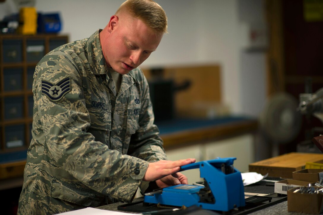 U.S. Air Force Staff Sgt. Josiah Sorrels, 8th Civil Engineer Squadron lock shop noncommissioned officer in charge, cuts a copy of a key using a punch at Kunsan Air Base, Republic of Korea, June 22, 2018. Maintaining locks and creating new keys are part of the day to day operations the structures shop is responsible for. (U.S. Air Force photo by Tech. Sgt. Charles McNamara)