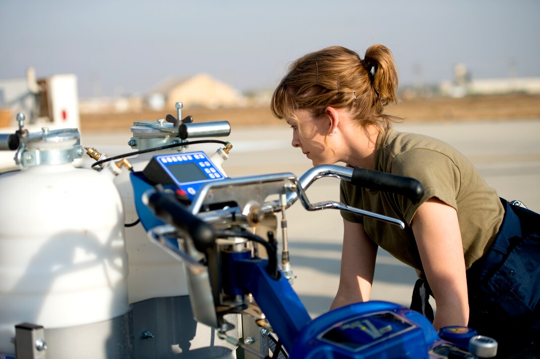 A U.S. Air Force Airman assigned to the 455th Air Expeditionary Wing at Bagram Airfield, Afghanistan helps paint flightline markings Nov. 24, 2018.