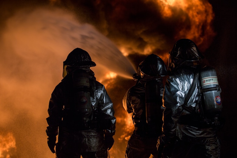 U.S. Marines with Aircraft Rescue and Firefighting use a hand line to extinguish a fuel fire Jan. 24, 2019 during live-burn training on Marine Corps Air Station Futenma, Okinawa, Japan. The training is held monthly to provide ARFF Marines with training scenarios to enhance their readiness to respond to any potential hazards or emergencies on the flight line. ARFF Marines entered the training area and used various hand lines, also known as a fire hose, to control and extinguish the fire.