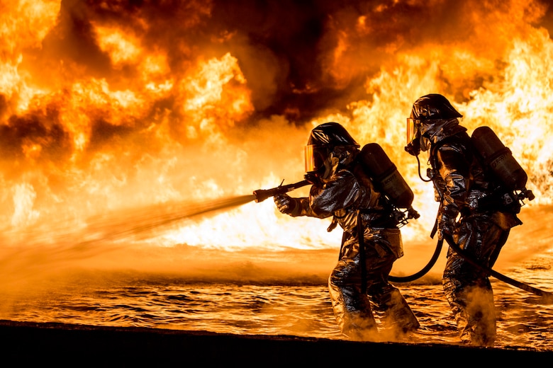 U.S. Marines with Aircraft Rescue and Firefighting use a hand line to extinguish a fuel fire Jan. 25, 2019, during live-burn training at Marine Corps Air Station Futenma, Okinawa, Japan. The training is held monthly to provide ARFF Marines with training scenarios to enhance their readiness to respond to any potential hazards or emergencies on the flight line. ARFF Marines entered the training area and used various hand lines, also known as a fire hose, to control and extinguish the fire.