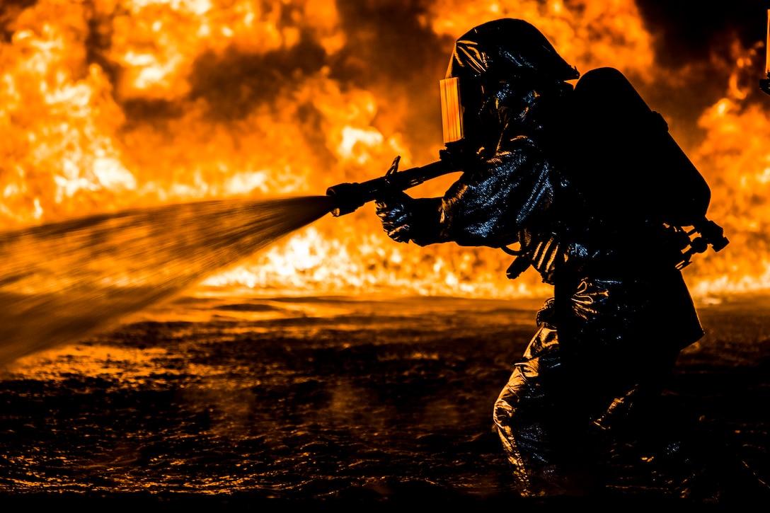 U.S. Marines with Aircraft Rescue and Firefighting use a hand line to extinguish a fuel fire Jan. 25, 2019 during live-burn training on Marine Corps Air Station Futenma, Okinawa, Japan. The training is held monthly to provide ARFF Marines with training scenarios to enhance their readiness to respond to any potential hazards or emergencies on the flight line. ARFF Marines entered the training area and used various hand lines, also known as a fire hose, to control and extinguish the fire.