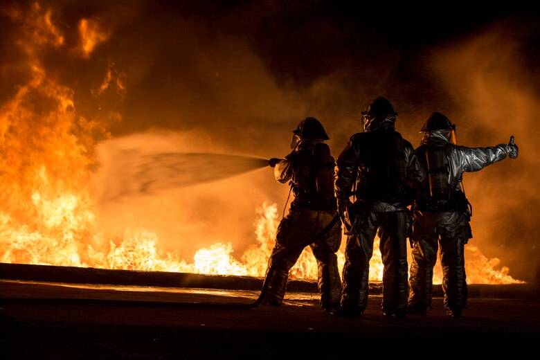 U.S. Marines with Aircraft Rescue and Firefighting use a hand line to extinguish a fuel fire Jan. 24, 2019 during live-burn training on Marine Corps Air Station Futenma, Okinawa, Japan. The training is held monthly to provide ARFF Marines with training scenarios to enhance their readiness to respond to any potential hazards or emergencies on the flight line. ARFF Marines entered the training area and used various hand lines, also known as a fire hose, to control and extinguish the fire.