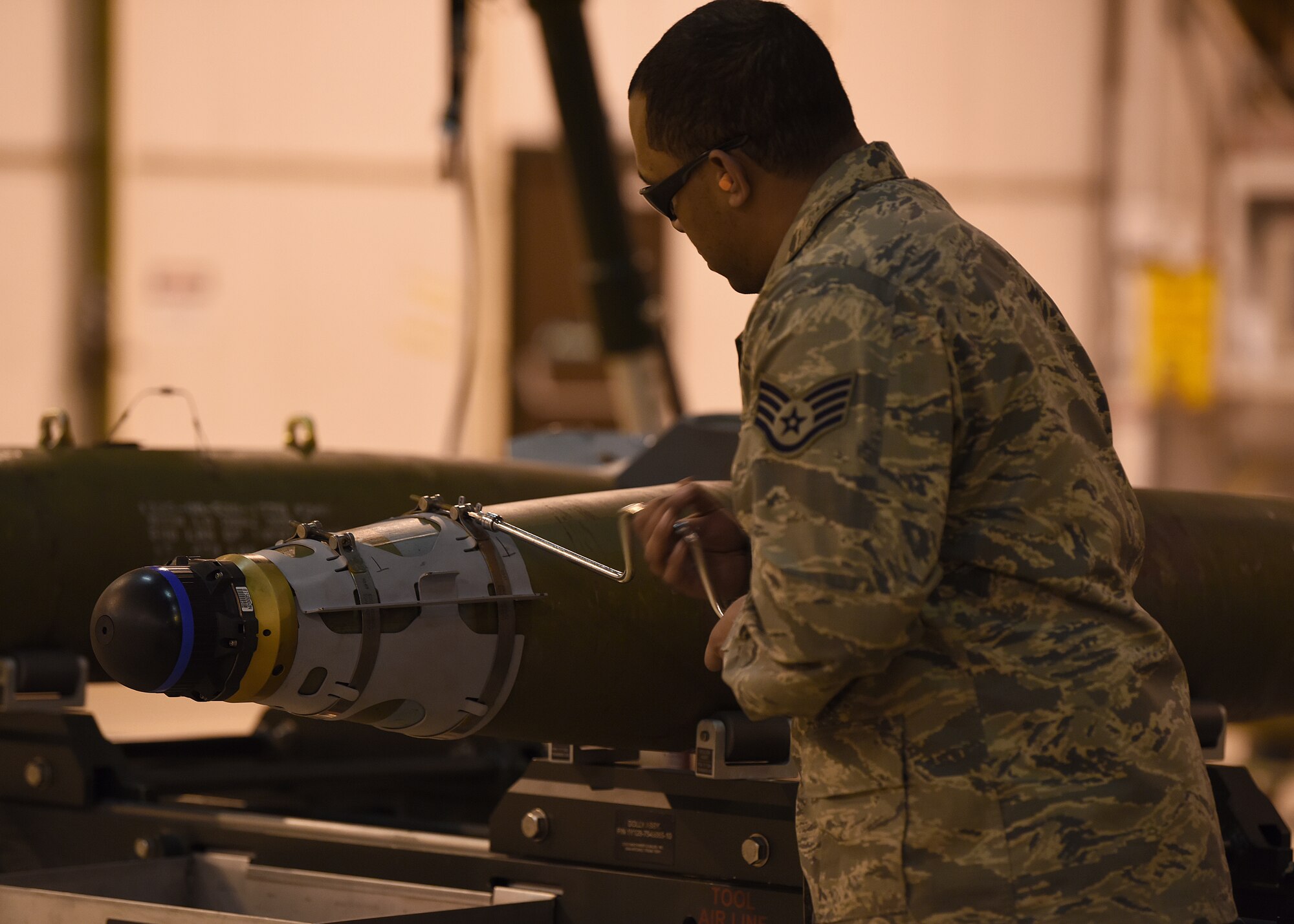 Staff Sgt. Deion Montana-Graham, 48th Munition Squadron conventional maintenance supervisor, uses a speed handle wrench to install the front strakes on an inert ordnance at Royal Air Force Lakenheath, England, Jan. 23, 2019. Practicing for the Air Force Combat Operations Competition provides a training opportunity for noncommissioned officers and Airmen they don’t normally get during day-to-day operations. (U.S. Air Force photo by Airman 1st Class Madeline Herzog)