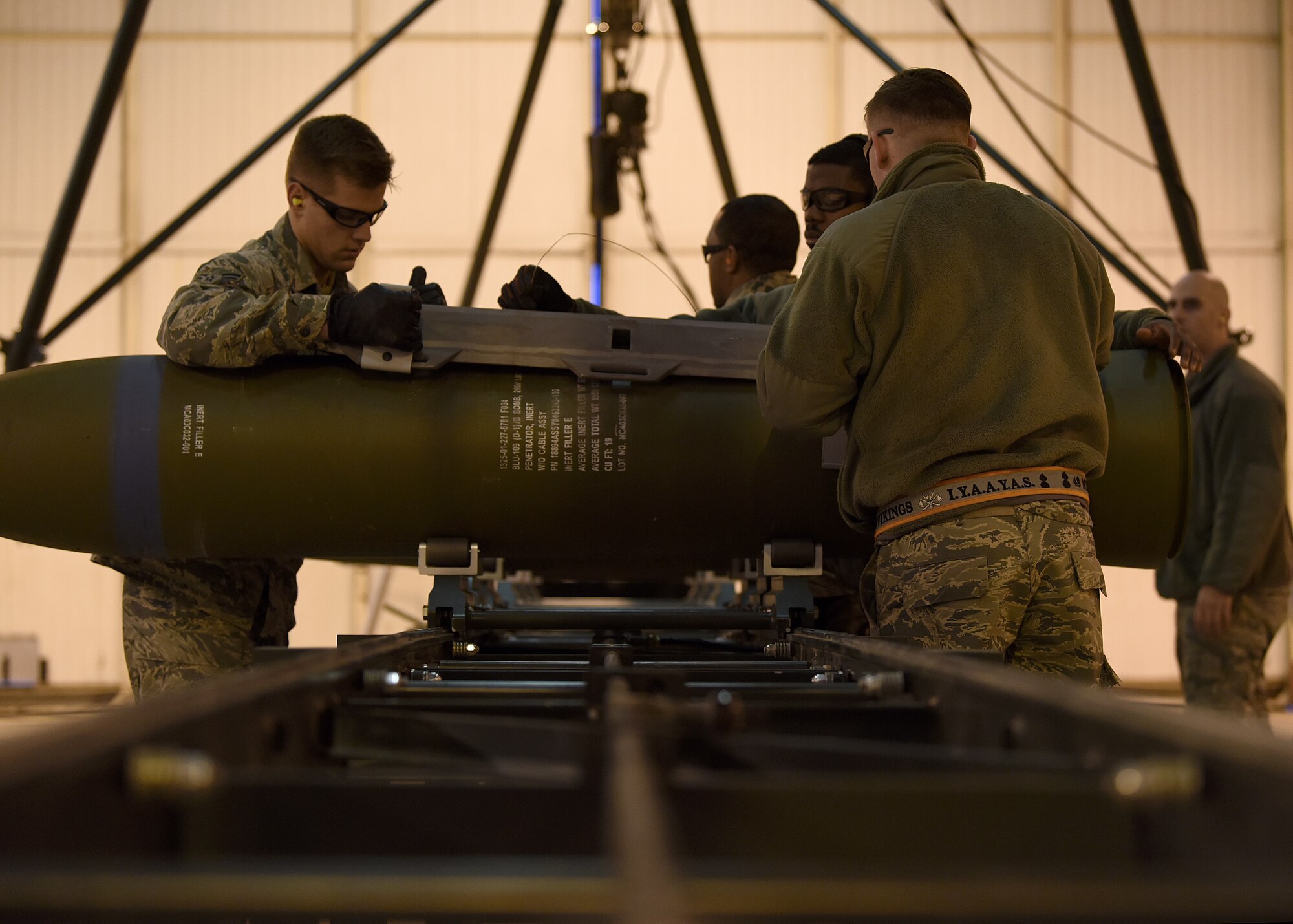 Airmen from the 48th Munitions Squadron attach the hardback assembly of an inert ordnance at Royal Air Force Lakenheath, England, Jan. 23, 2019. The Airmen were training for the Air Force Combat Operations Competition, an annual munitions-building competition designed to test participants on all of the aspects used by ammo personnel in wartime operations. (U.S. Air Force photo by Airman 1st Class Madeline Herzog)