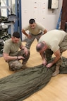 The G12E Parachute is the focus of cross-training for Soldiers from the 56th Quartermaster Rigger Support Team, RI Army National Guard and their RI Air National Guard counterparts, January 5, 2019, Quonset Point, North Kingstown RI. Training on the G12E Cargo Parachute increases proficiency on air drop systems and improves interoperability.  (U.S. Army National Guard Photo by Sgt. 1st Class Michael A. Simmons)