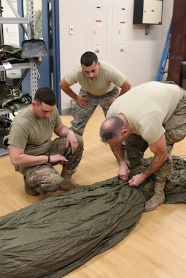 The G12E Parachute is the focus of cross-training for Soldiers from the 56th Quartermaster Rigger Support Team, RI Army National Guard and their RI Air National Guard counterparts, January 5, 2019, Quonset Point, North Kingstown RI. Training on the G12E Cargo Parachute increases proficiency on air drop systems and improves interoperability.  (U.S. Army National Guard Photo by Sgt. 1st Class Michael A. Simmons)