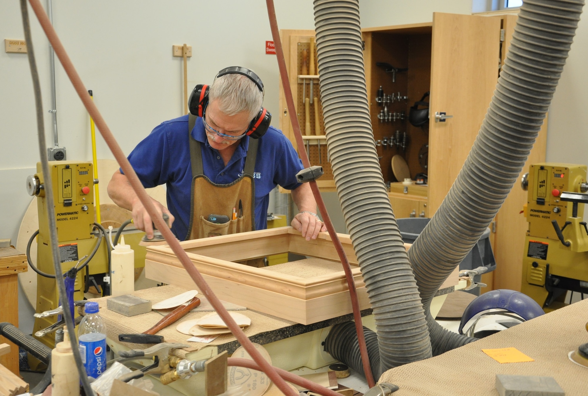 Dan Peck, woodworker, completes finishing work with a circular saw sander for a shadow box at the Consolidated Hobby Complex, Bldg. 1227 in the Kittyhawk area. (U.S. Air Force photos/W. Eugene Barnett)