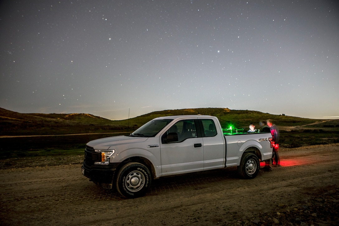 Key leaders with Planck Aerosystems converse about the Shearwater drone capabilities during night time testing on East MCAS Miramar, Calif., Jan. 24. As an autonomous systems testbed, MCAS Miramar hosted the Shearwater drone system, which is capable of landing on moving vehicles and is primarily used to assist in security, search and rescue, convoy support and special operations by providing live aerial surveillance to the user. (U.S. Marine Corps Photo by Sgt. Jake McClung)