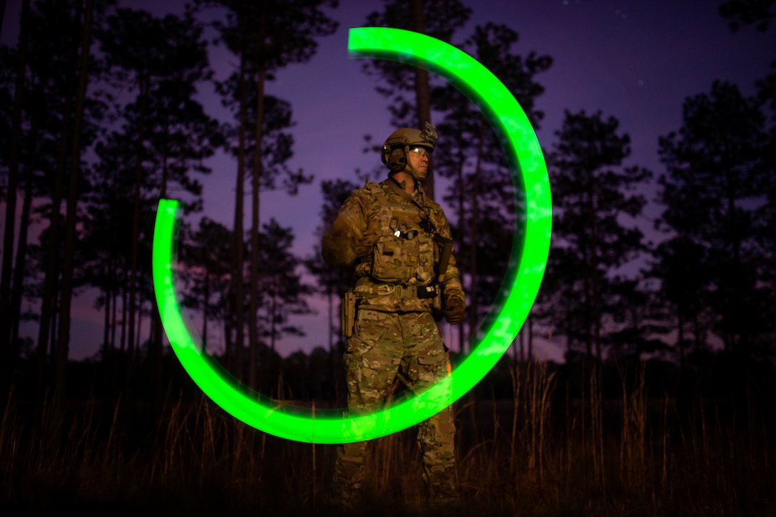 A soldier standing in front of trees.