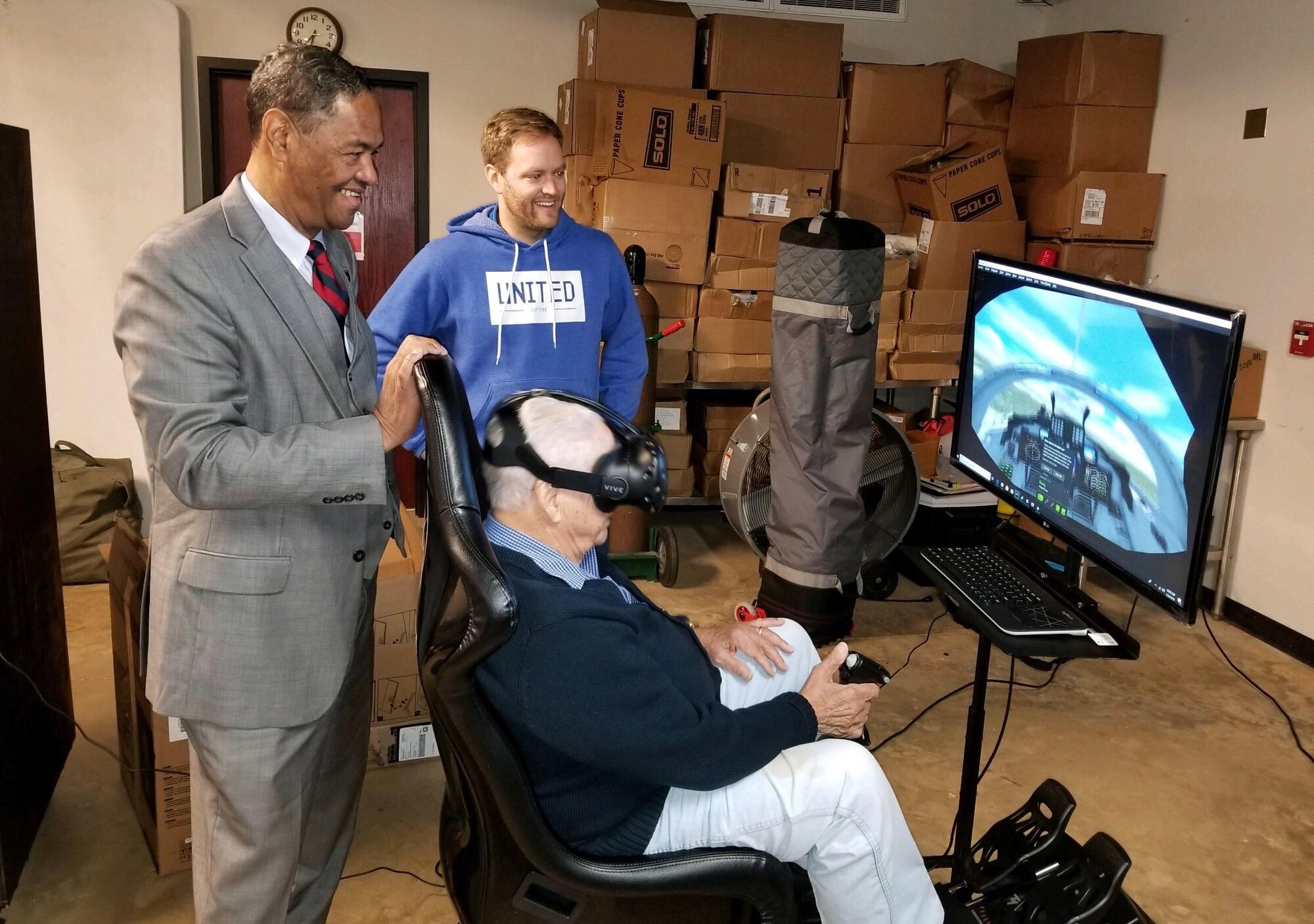 Retired Air Force Lt. Col. George Hardy (left), a former Tuskegee Airman, flies the VR flight simulator.