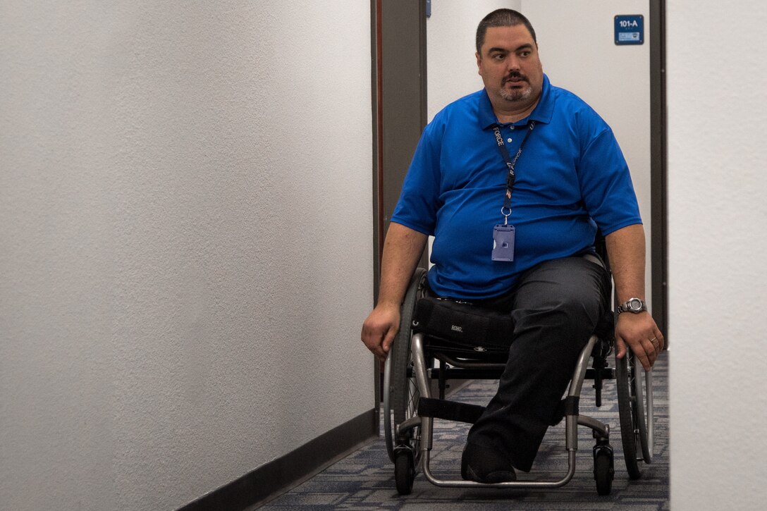 Kevin Waterhouse serves as the wing commander’s secretary for the 403rd Wing at Keesler Air Force Base, Mississippi. He was in an accident at age 17 that left him paralyzed from the chest down. He didn't let that get him down or stop him from achieving his goals of getting an advanced degree, writing a book, and getting a federal job. (U.S. Air Force photo by Staff Sgt. Shelton Sherrill)