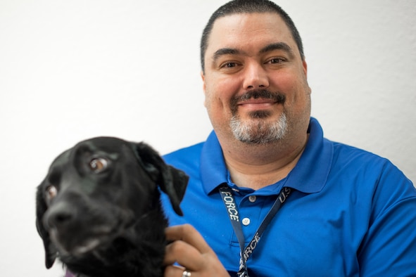 Kevin Waterhouse, along with his service dog Jade, serves as the wing commander’s secretary for the 403rd Wing at Keesler Air Force Base, Mississippi. He was in an accident at age 17 that left him paralyzed from the chest down. He didn't let that get him down or stop him from achieving his goals of getting an advanced degree, writing a book, and getting a federal job. (U.S. Air Force photo by Staff Sgt. Shelton Sherrill)