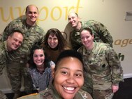 Seven Soldiers - male and female - posing for photo at Ronald McDonald House