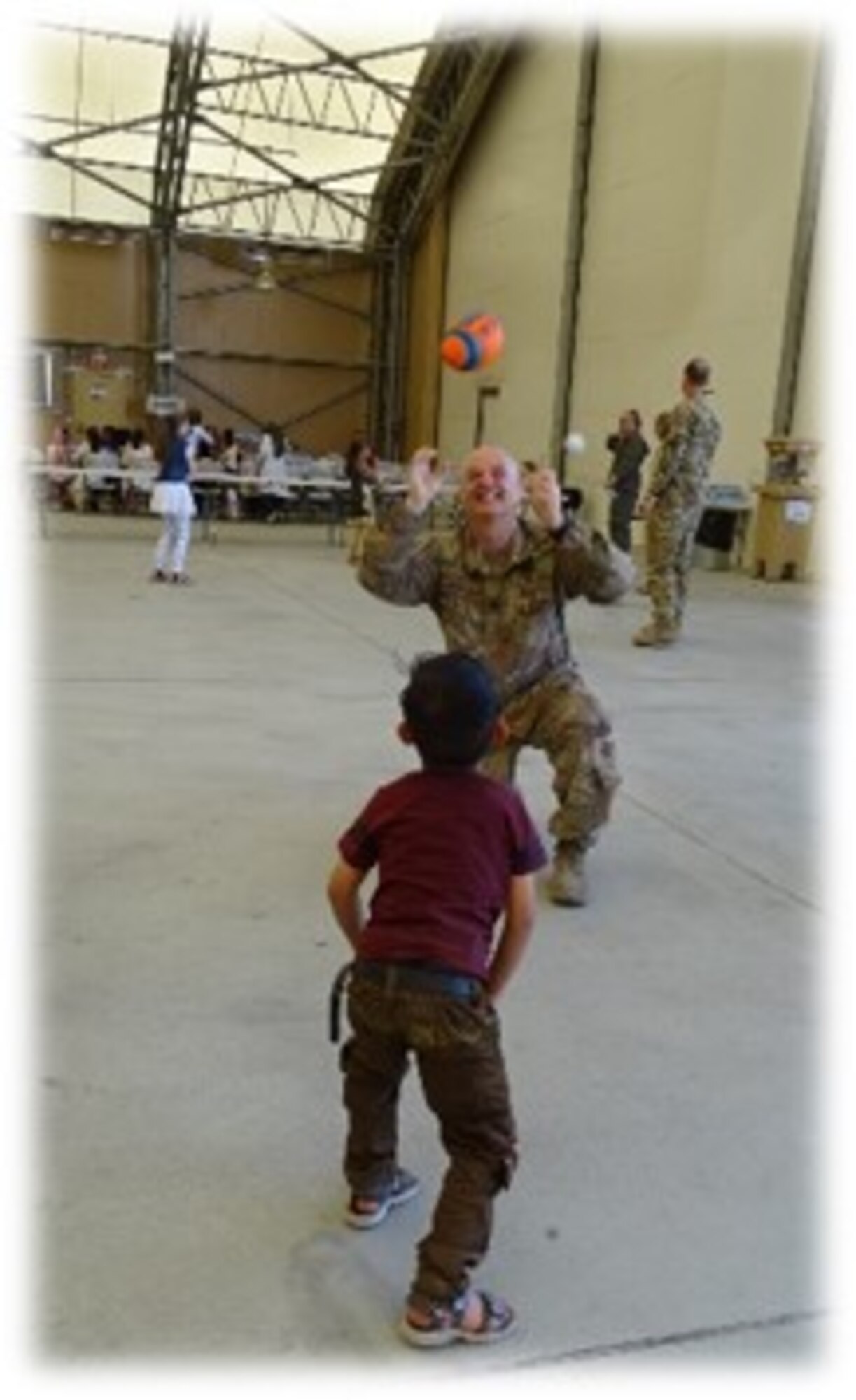 Chaplain Lt. Col. John W. Shipman plays catch with an Afghan child during an outreach event to the children of the Afghan Martyrs and a local Kabul orphanage to help build positive rapport with the local community on June 25, 2018.