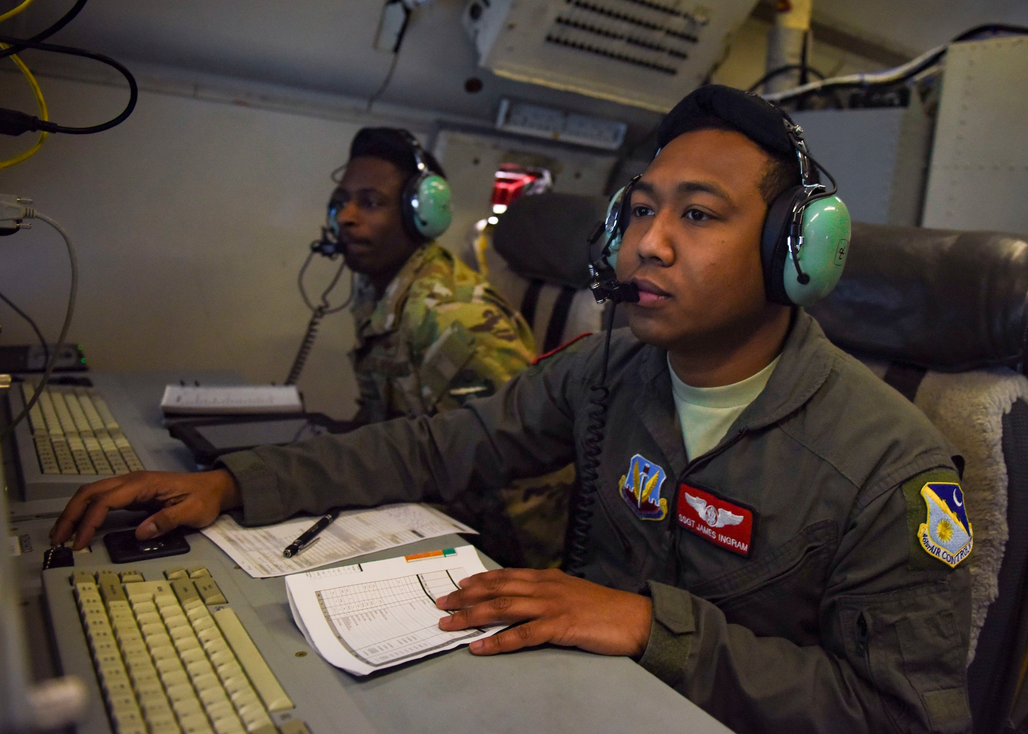 Two Airmen review radar imagery.
