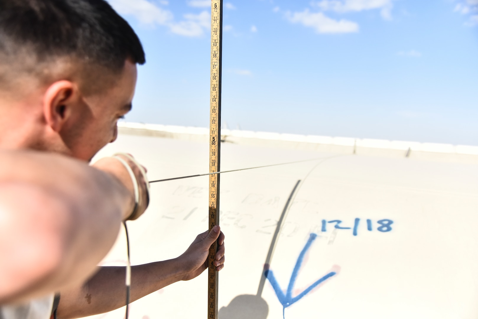 U.S. Air Force Senior Airman Tyler Ruano, 380th Expeditionary Logistics Readiness Squadron fuels operations technician, measures a fuel bladder at Al Dhafra Air Base, United Arab Emirates, Jan. 21, 2019. The fuel bladders have approximately the same thickness of a water bed liner, which is strong enough to hold 210,000 gallons of fuel. (U.S. Air Force photo by Senior Airman Mya M. Crosby)