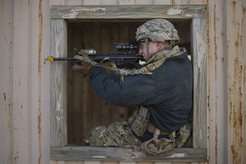 A Soldier assigned to the 2-325th Airborne Infantry Regiment guards a window of an enemy compound during the air assault portion of the cold-weather gunnery qualification training on Joint Base McGuire-Dix-Lakehurst, New Jersey, Jan. 17, 2019. The Soldiers were air assaulted in the target compound and rated on how well the teams worked together to infiltrate it and apprehend any enemies found. (U.S. Air Force photo by Airman 1st Class Ariel Owings)