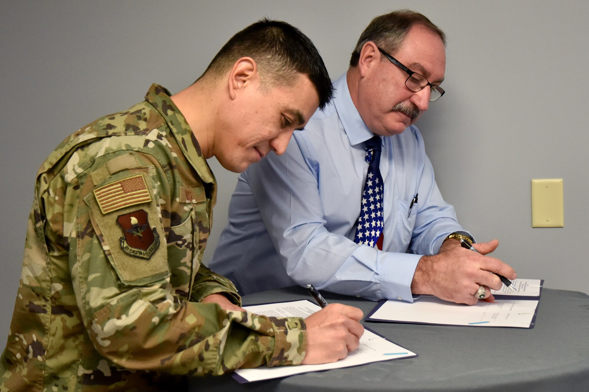 U.S. Air Force Col. Ricky Mills, 17th Training Wing commander, signs the Career Skills Program Memorandum of Understanding alongside Concho Valley Workforce Development Board Deputy Executive Director Mr. Randy LeCompte at the Business Resource Center on Jan. 25, 2019. This MOU helps transitioning service members develop workforce skills and potentially secure internships or employment within the local community. (U.S. Air Force photo by 2nd Lt. Matthew Stott/Released)