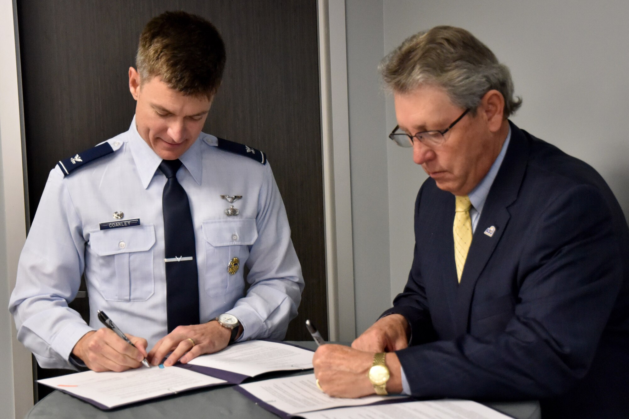 U.S. Air Force Col. Thomas Coakley, 17th Training Group commander, signs the Doolittle Speaker Series Memorandum of Understanding alongside Angelo State University Provost Dr. Donald Topliff at the Business Resource Center on Jan. 25, 2019. This MOU will help both community and base members enhance professional understanding of key events and topics based on insights from prominent speakers. (U.S. Air Force photo by 2nd Lt. Matthew Stott/Released)