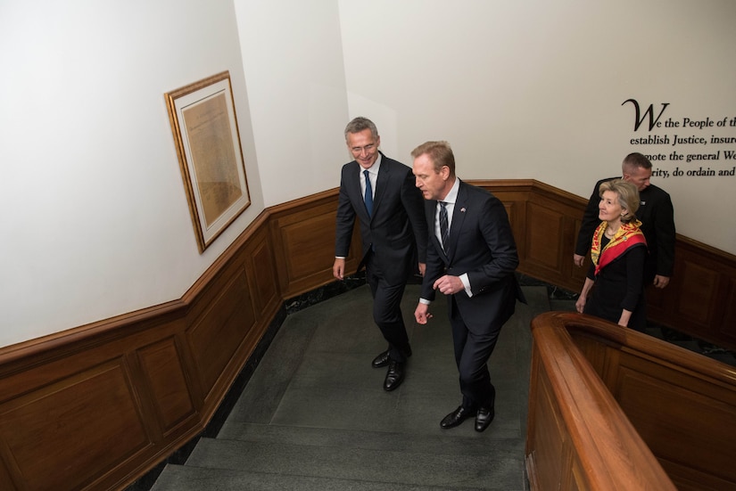 Two men walk up the stairs.