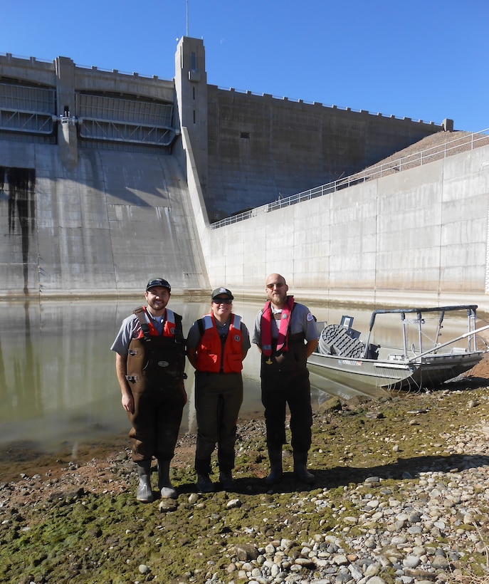 JOHN MARTIN RESERVOIR, Colo. – John Martin park rangers (l-r) Tucker Feyder, Valerie Thompson and Christopher Gauger stand in front of the electrofishing boat at the bottom of the dam, Nov. 1, 2018. Part of the $6 million stilling basin dewatering project involves the removal of the fish from the stilling basin.