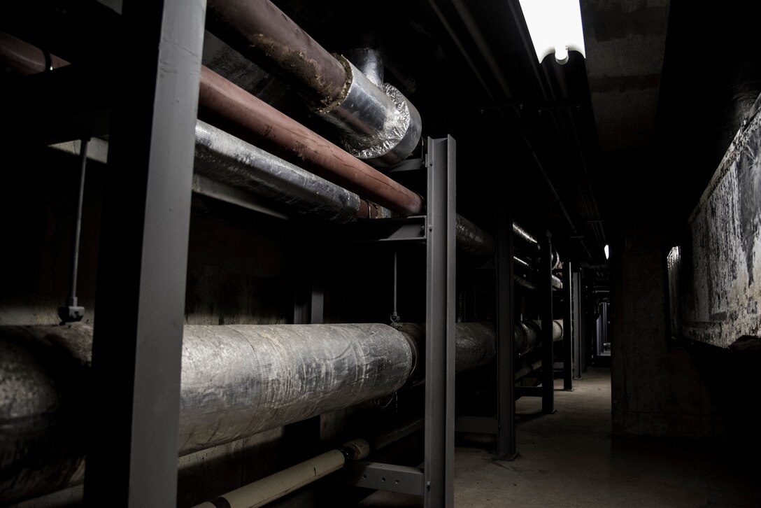 Pipes and brackets located underneath the pool assist the water filtration and heating system at Yokota Air Base, Japan, Jan. 23, 2019. These pipes and brackets were damaged from corrosion caused by chlorinated water leaked by the pool. (U.S. Air Force photo by Machiko Arita)