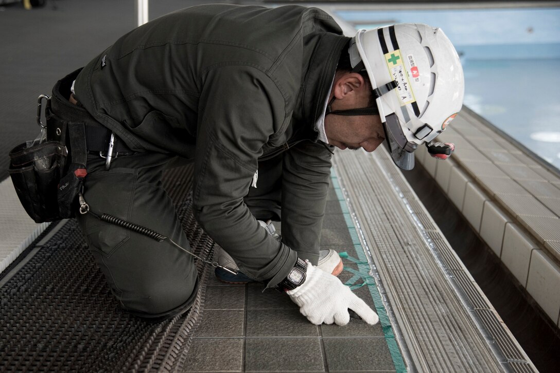 A contractor prepares to replace the seals around the Natatorium pool at Yokota Air Base, Japan, Jan. 23, 2019.