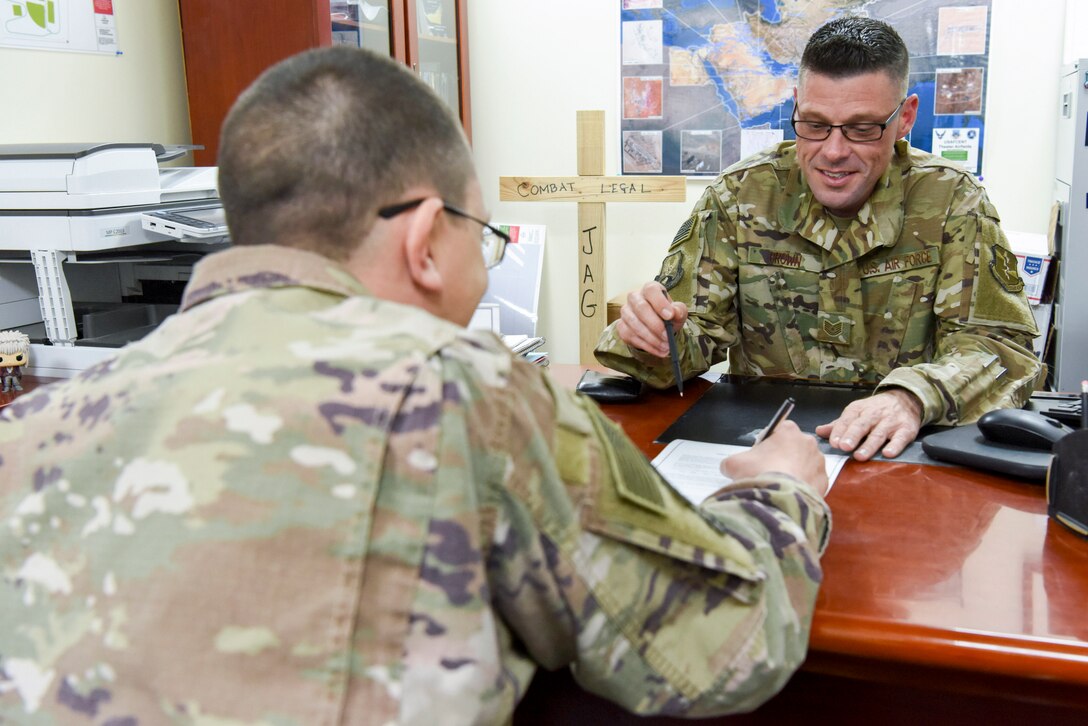 Tech. Sgt. Rich Brown, 380th AEW NCOIC of legal office, assists a customer with a power of attorney, Jan. 24, 2019 at Al Dhafra Air Base, United Arab Emirates.
