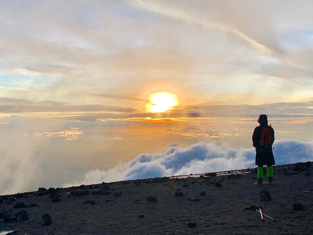 Jeff Crow, material planner in the Defense Logistics Agency Troop Support’s Industrial Hardware supply chain, stands atop Tanzania’s Mount Kilimanjaro, watching the sunset from above the clouds during a trip in December 2018.