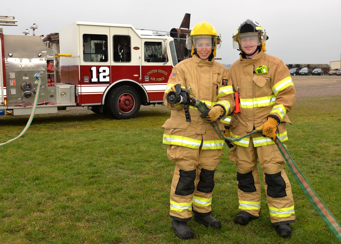 U.S. Air Force Chief Master Sgt. Kristina Rogers, left, 100th Air Refueling Wing command chief, poses for a photo with Airman 1st Class Adam Strizak, 100th Civil Engineer Squadron firefighter, before participating in Class A structural live-fire training at RAF Mildenhall, England, Jan. 24, 2019. The 100th ARW command chief participated in the training, performed semi-annually, to get an idea of what the RAF Mildenhall firefighters go through to keep up-to-date in their fundamental skills. Class A training burns combustibles such as wood and paper, and is one of the most realistic forms of live-fire training conducted. (U.S. Air Force photo by Karen Abeyasekere)