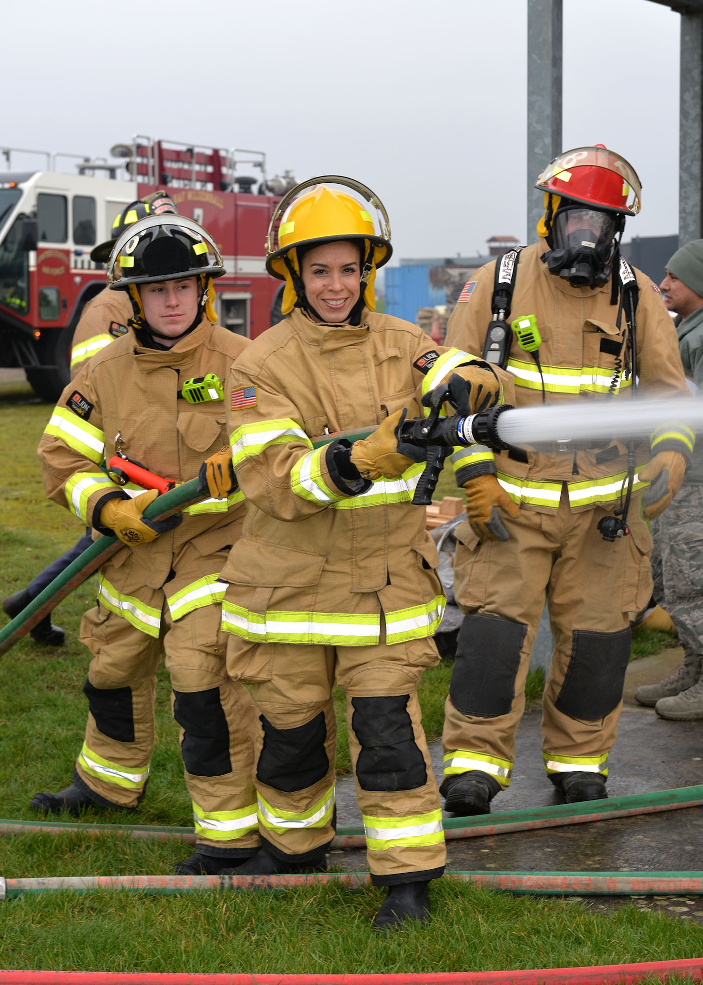 U.S. Air Force Chief Master Sgt. Kristina Rogers, 100th Air Refueling Wing command chief, uses the fire hose with assistance from Airman 1st Class Adam Strizak, left, 100th Civil Engineer Squadron firefighter, and Lead Firefighter Simon Evans, 100th CES Fire Department crew manager, during Class A structural live-fire training at RAF Mildenhall, England, Jan. 24, 2019. The 100th ARW command chief participated in the training, performed semi-annually, to get an idea of what the RAF Mildenhall firefighters go through to keep up-to-date in their fundamental skills. Class A training burns combustibles such as wood and paper, and is one of the most realistic forms of live-fire training conducted. (U.S. Air Force photo by Karen Abeyasekere)