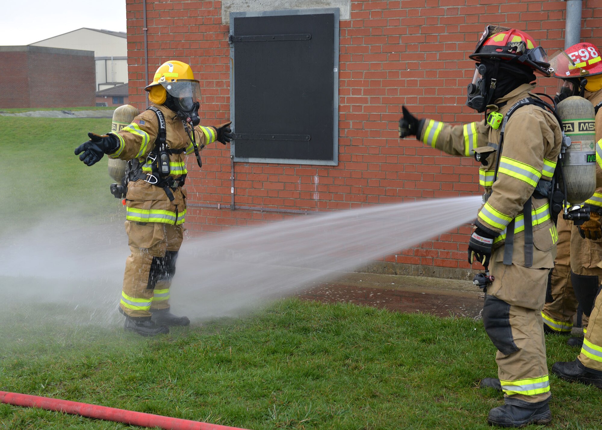 Firefighters from the 100th Civil Engineer Squadron Fire Department hose down U.S. Air Force Chief Master Sgt. Kristina Rogers, 100th Air Refueling Wing command chief, as part of the decontamination process after she participated in Class A structural live-fire training at RAF Mildenhall, England, Jan. 24, 2019. The 100th ARW command chief participated in the training, performed semi-annually, to get an idea of what the RAF Mildenhall firefighters go through to keep up-to-date in their fundamental skills. Class A training burns combustibles such as wood and paper, and is one of the most realistic forms of live-fire training conducted. (U.S. Air Force photo by Karen Abeyasekere)